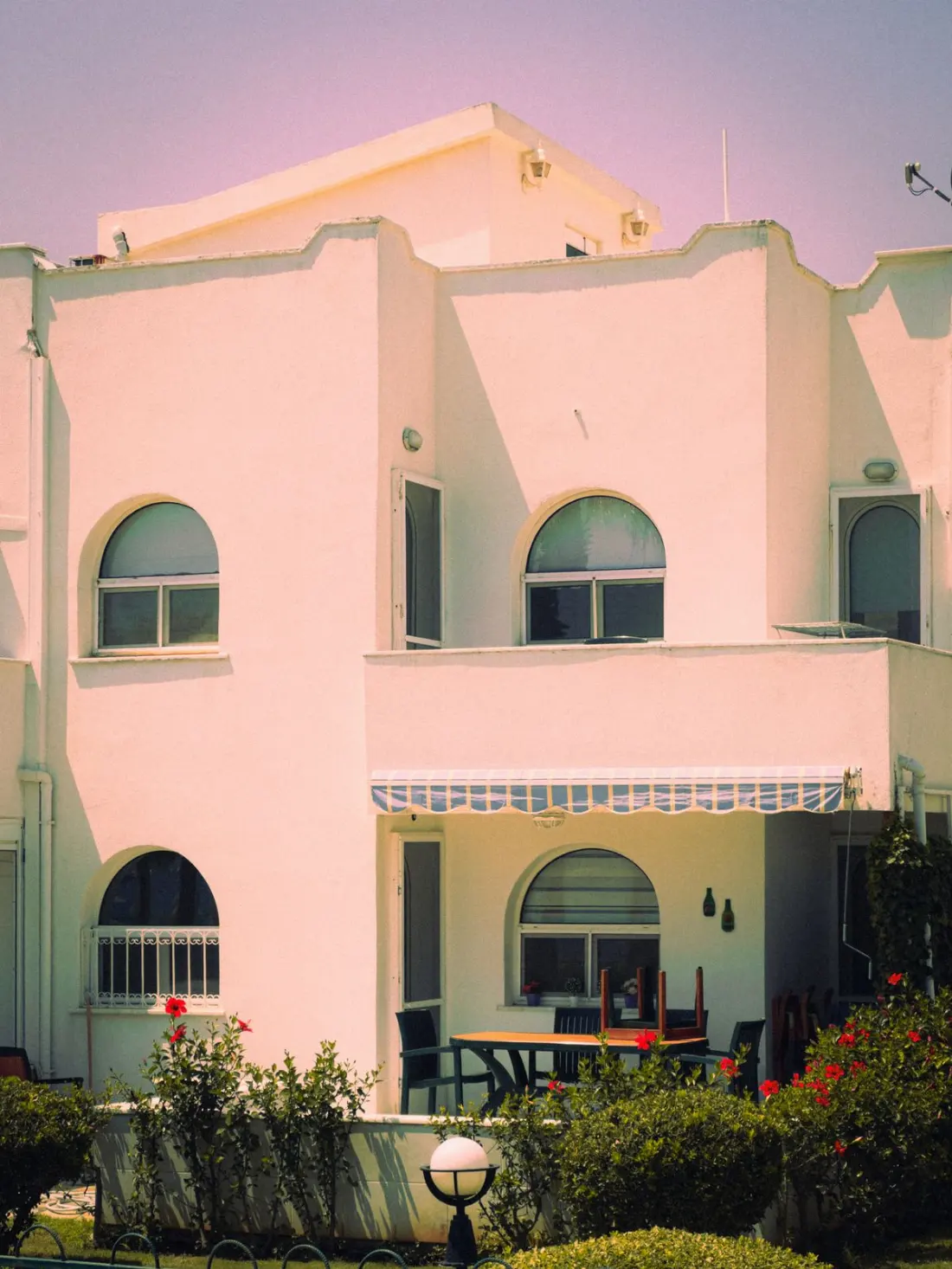 Illustrative photograph: White Mediterranean house with garden and arched windows
