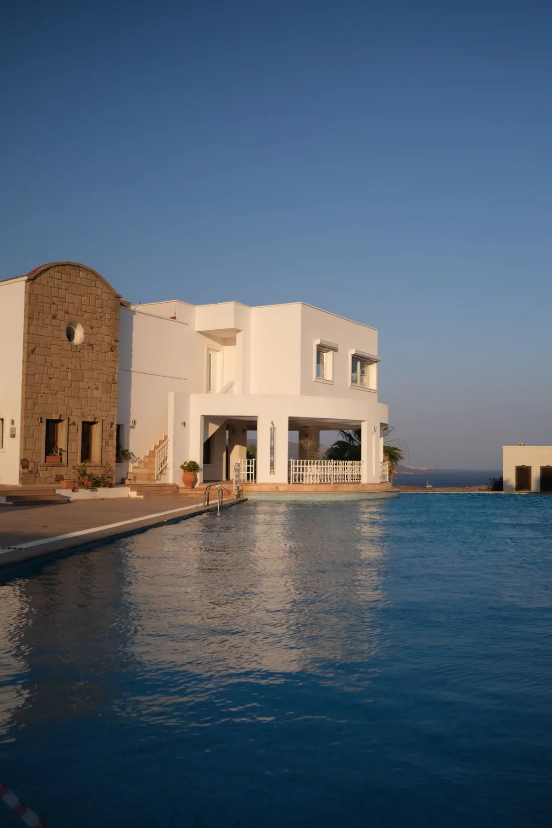 Illustrative photograph: Elegant Mediterranean villa with pool and sea view at sunset
