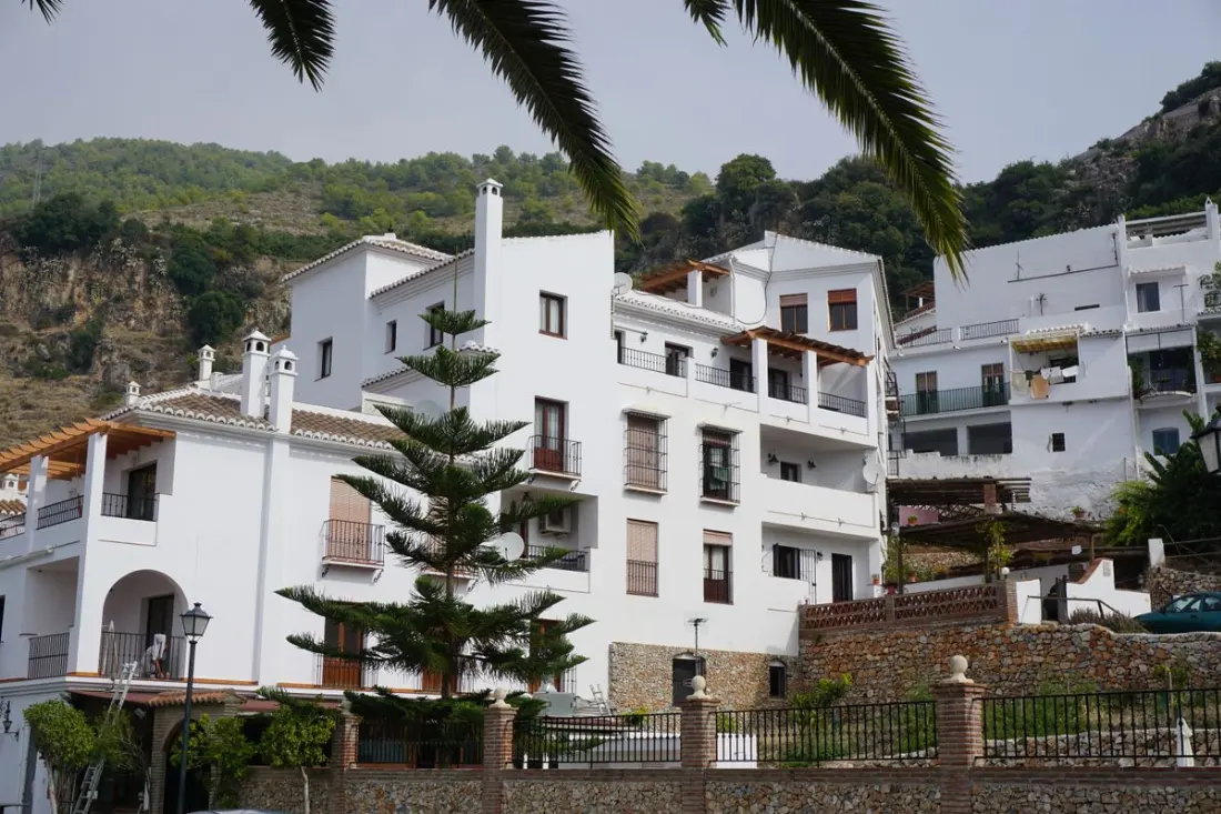 Illustrative photograph: White Spanish townhouses in a Mediterranean hillside setting